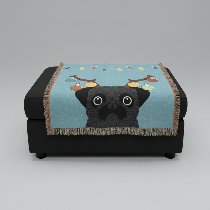 Black pug blanket with reindeer antlers on a black ottoman against a gray background