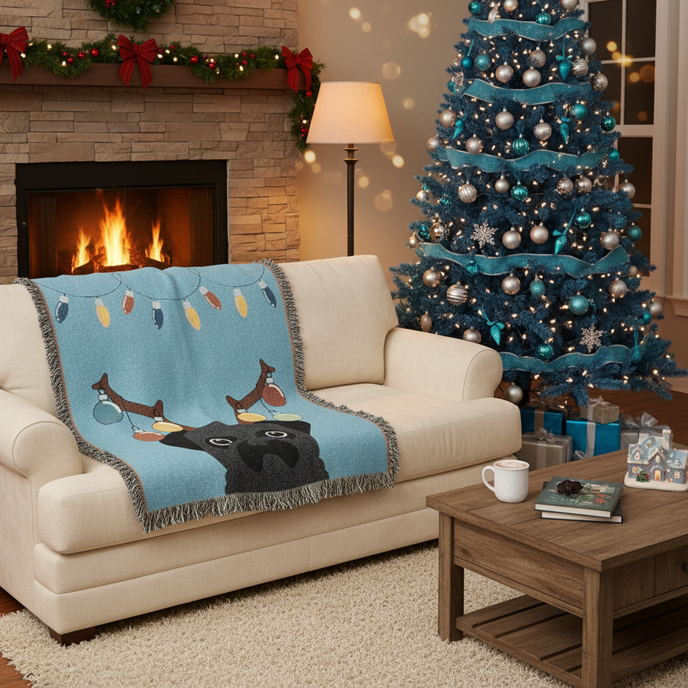 Living room with a decorated Christmas tree, fireplace, and a blanket with a pug design on a couch. Pug has christmas bulbs on antlers